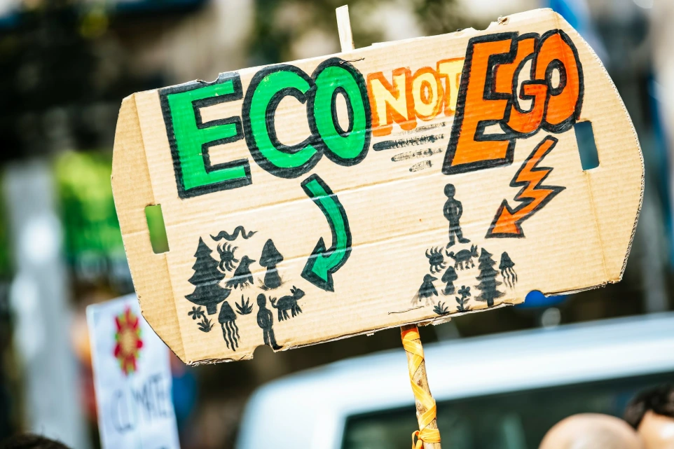 person holding Eco Not Ego signage